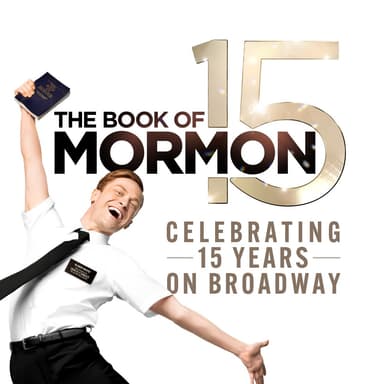 A person in a white shirt and black tie holds up "The Book of Mormon" on a stage, smiling with one hand raised.